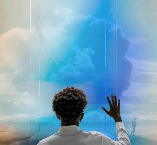 白い服を着た男性が、青と白の雲が広がる空と抽象的な幾何学模様の向こうを、透明な壁に手を触れて見つめています。