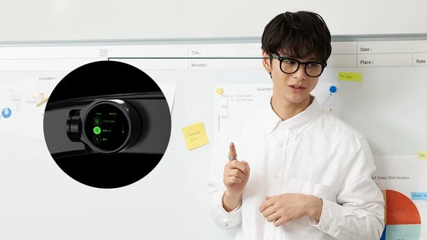 眼鏡をかけた男性がホワイトボードの前でプレゼンテーションを行っている