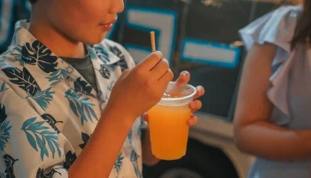 海藻由来ストローでドリンクを飲む子供