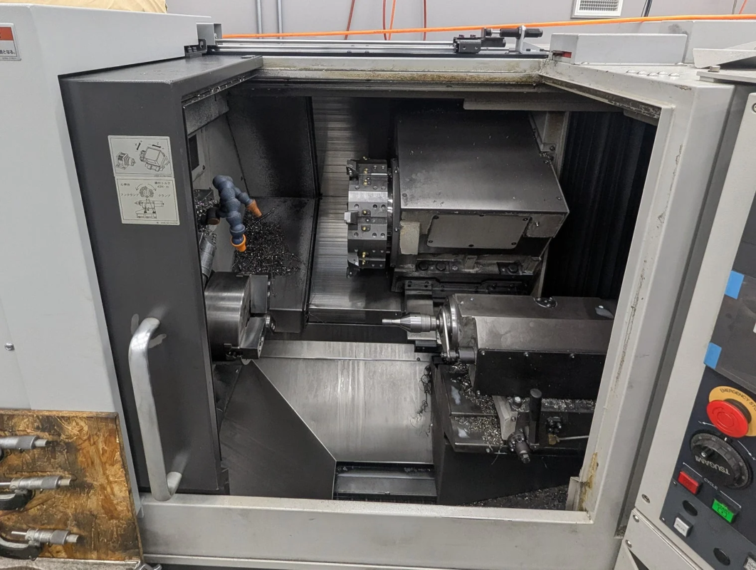 稼働中のCNC旋盤またはターニングセンタの内部が写っています