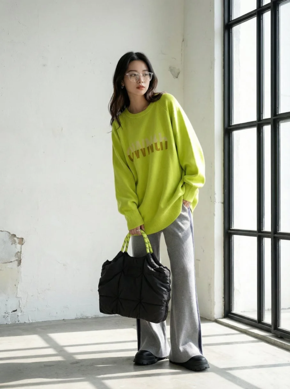 女性、モデル、ファッション、コーディネート、セーター、ニット、ライムグリーン、ネオンカラー、オーバーサイズ、ワイドパンツ、グレーパンツ、メガネ、バッグ、トートバッグ、キルティングバッグ、室内、自然光、カジュアル、リラックス
