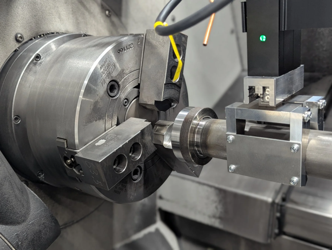 金属加工機械の旋盤チャックにワークがしっかりと固定され、その周囲で加工または測定が行われている様子