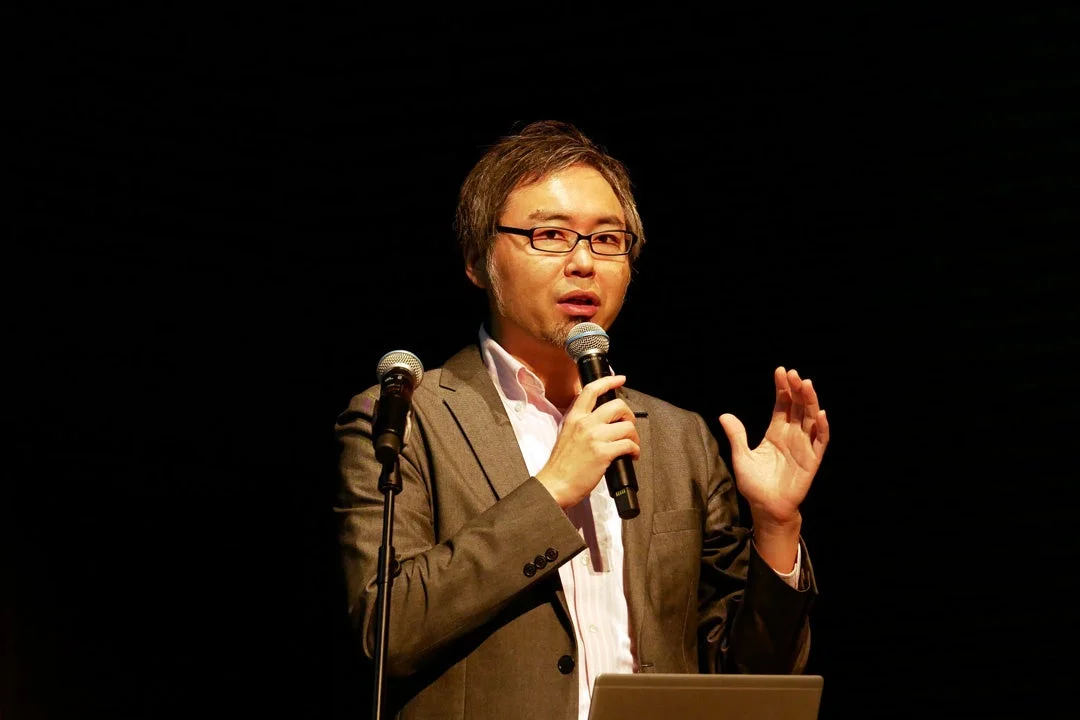 ステージ上でスピーチする本橋 賢二氏