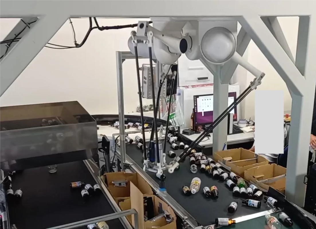 ロボットアームがボトルを仕分けしている画像