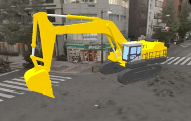 街中の道路に黄色のショベルカーが配置された画像です。