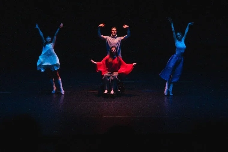 暗い舞台で4人のダンサーがパフォーマンスを披露している様子。