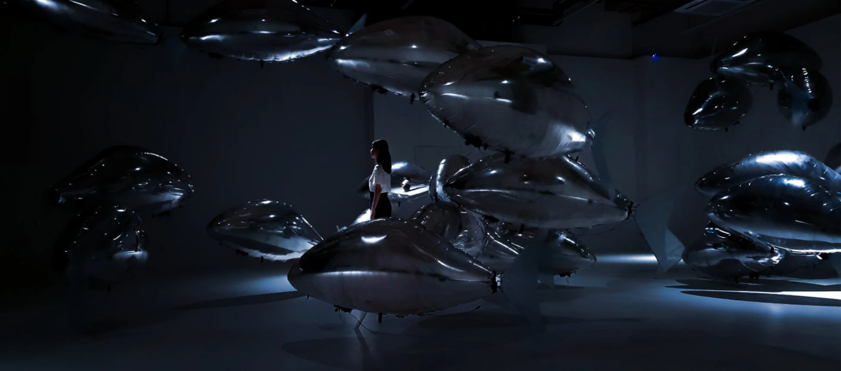 銀色の風船のようなオブジェが浮遊するアート