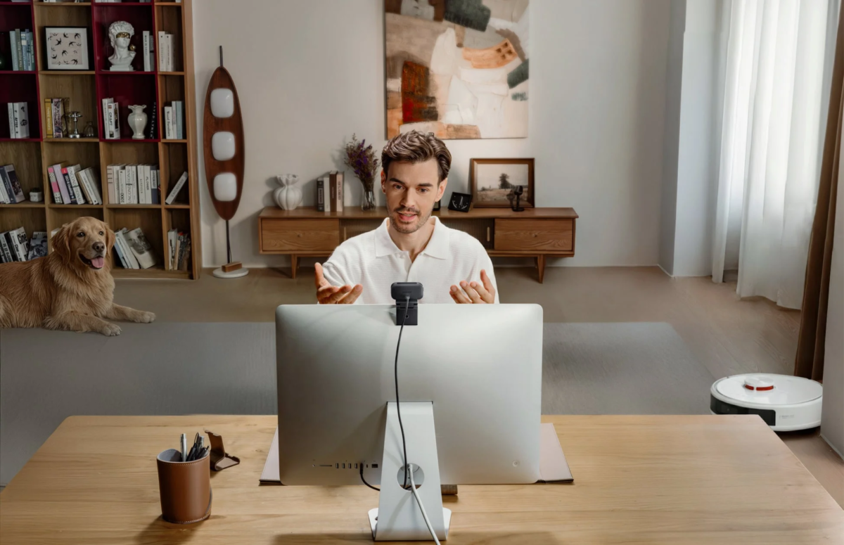 在宅勤務でビデオ会議をする男性と犬