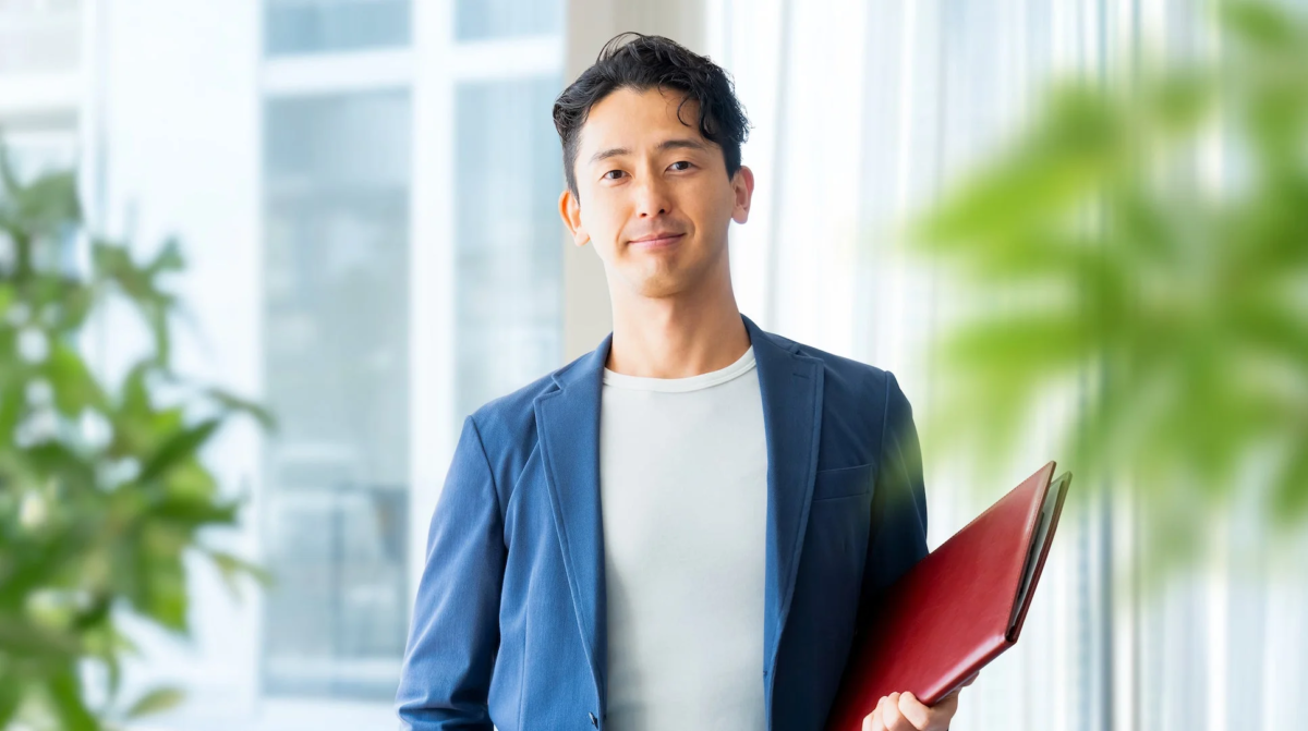 青いジャケットを羽織った笑顔の男性