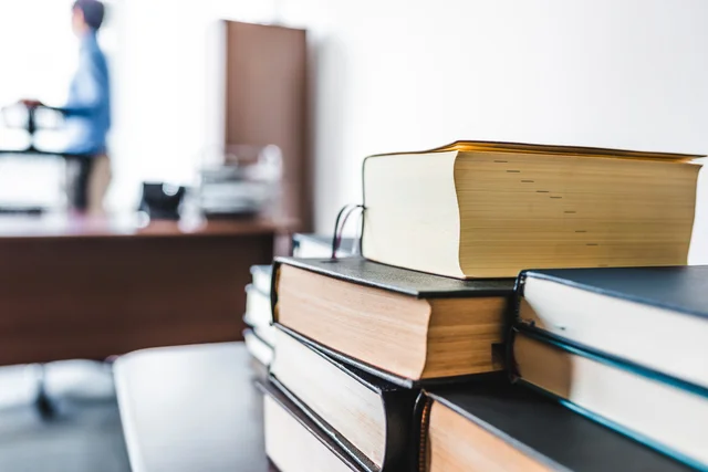 本が積み重ねられた机のイメージ