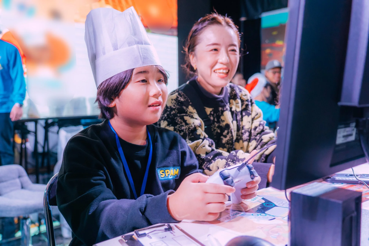 シェフ帽をかぶった少年がゲームコントローラーを操作しています