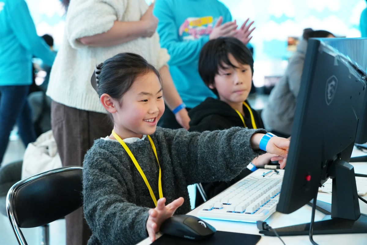 笑顔の女の子がコンピューターを操作しています