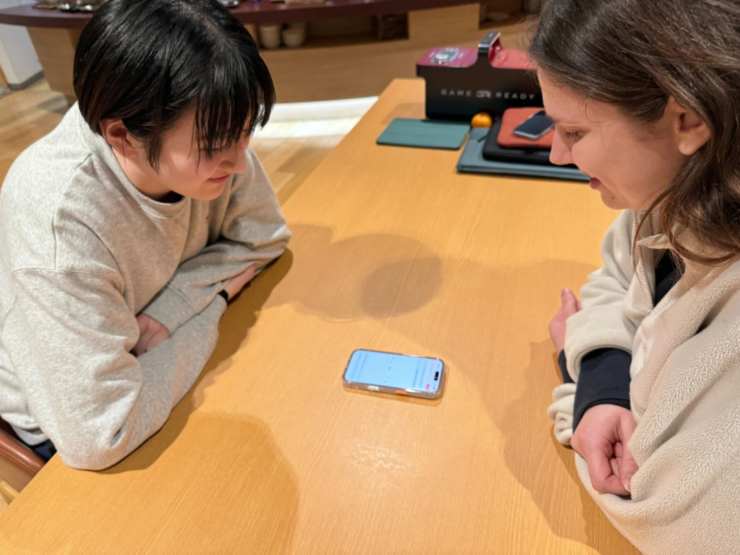 スマートフォンを覗き込む二人の女性