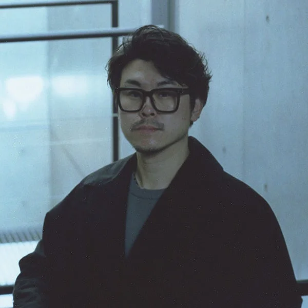 黒縁メガネをかけたアジア系の男性のポートレート