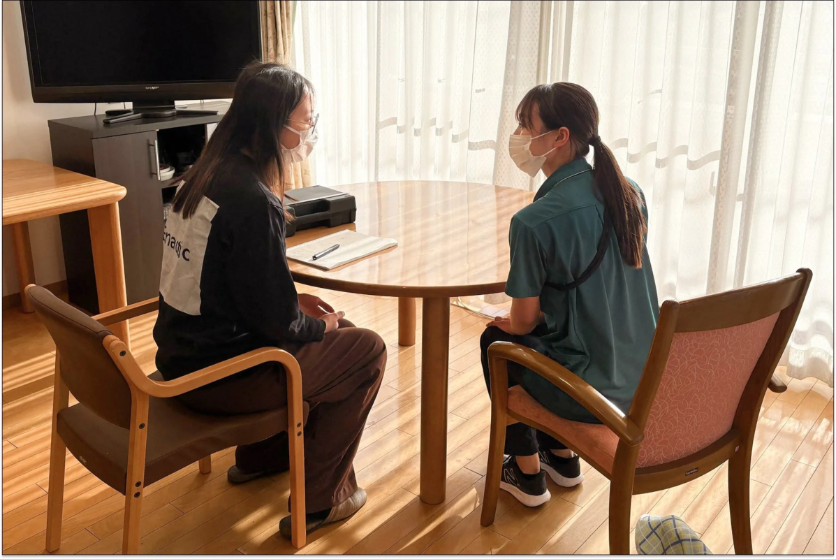 マスクを着用した2人の女性が会話している様子