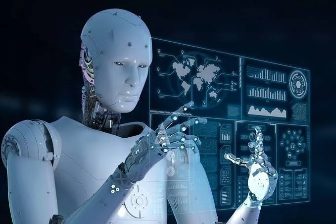 白い人型ロボットがデジタルインターフェースに触れ、データを操作している様子