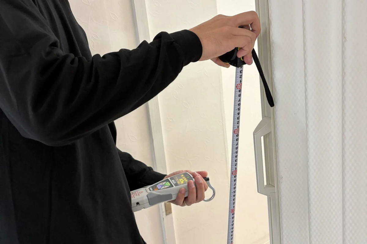 メジャーとデジタルフォースゲージを使い測定を行っている様子