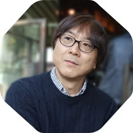 眼鏡をかけた中高年のアジア人男性のポートレートです。